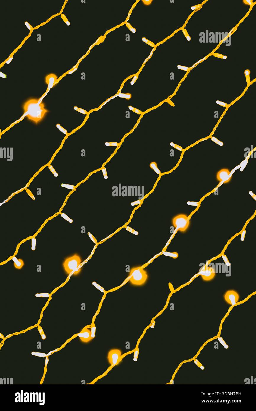 Un display di luci a corde è disposto su uno sfondo scuro. Le luci si accendono, creando una calda luce soffusa. Questa configurazione può essere utilizzata per feste, gatheri Foto Stock