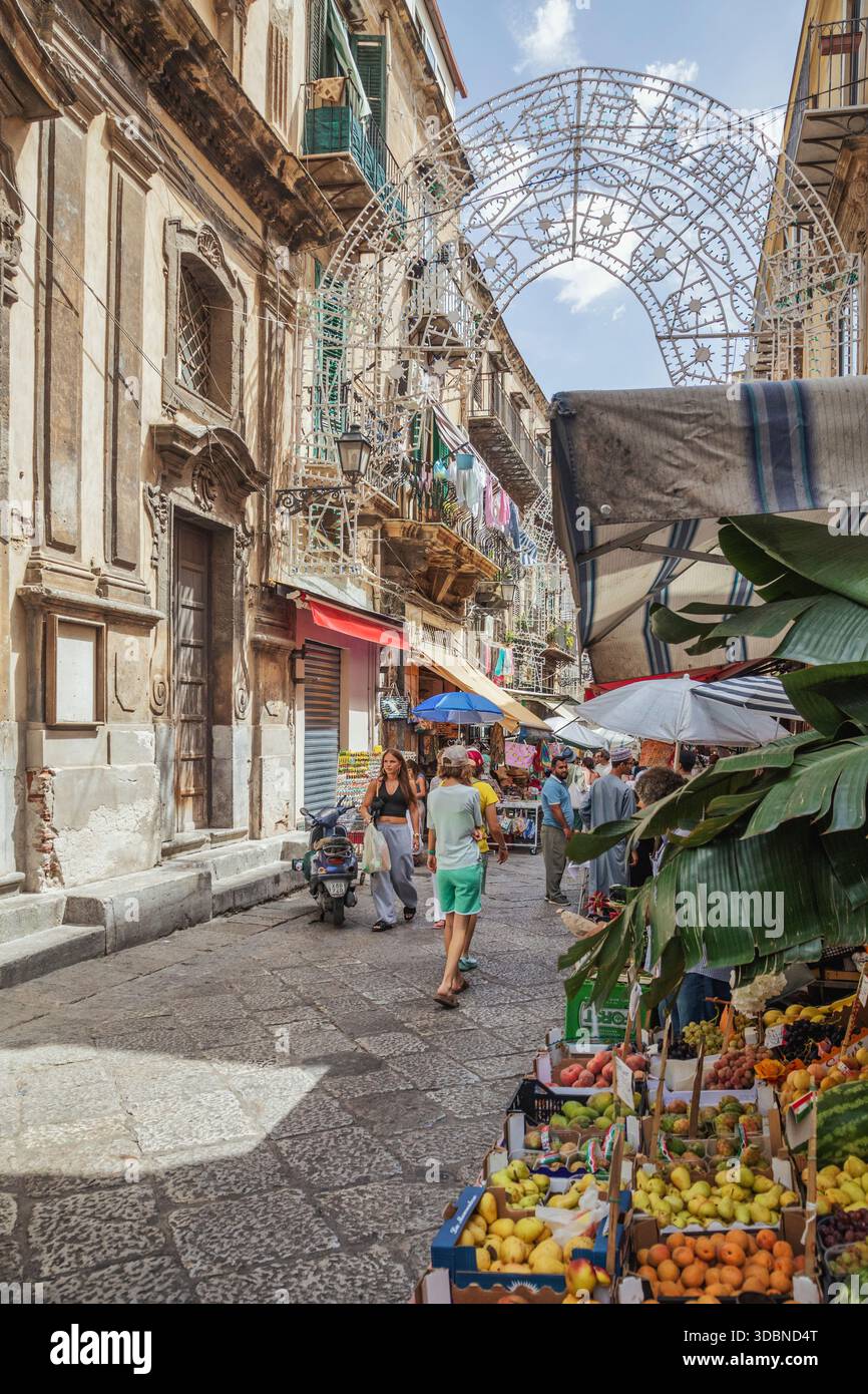 Bancarelle colorate di frutta e verdura con tradizionali lampioni palermitani al mercato del Capo, uno dei mercati più famosi e vivaci della città. Palermo, Sicilia, Italia Foto Stock