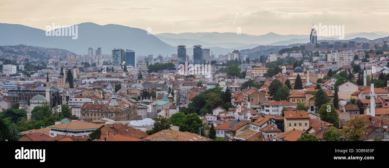 Vista panoramica di Sarajevo con tetti rossi, moschee storiche, moderni grattacieli e montagne circostanti al tramonto. Sarajevo, Bosnia ed Erzegovina Foto Stock