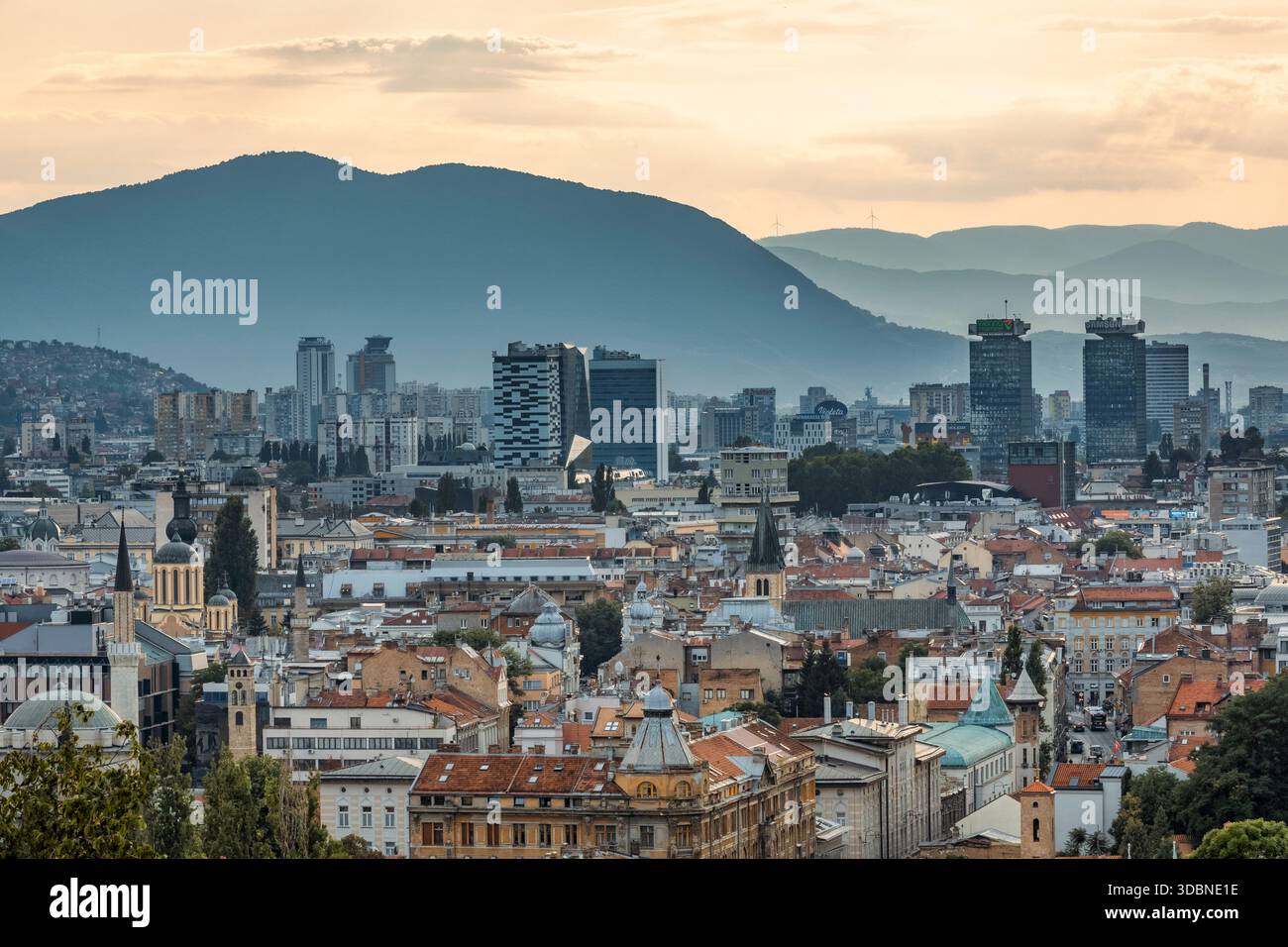 Vista panoramica di Sarajevo con un mix di tetti storici, chiese, moschee e moderni grattacieli, circondati dalle montagne, Bosnia ed Erzegovina Foto Stock
