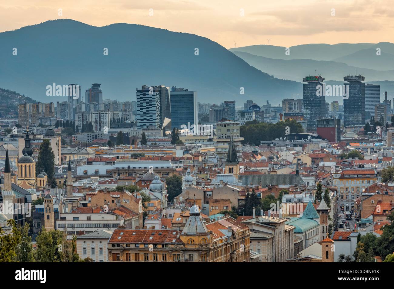 Vista panoramica di Sarajevo con un mix di tetti storici, chiese, moschee e moderni grattacieli, circondati dalle montagne, Bosnia ed Erzegovina Foto Stock