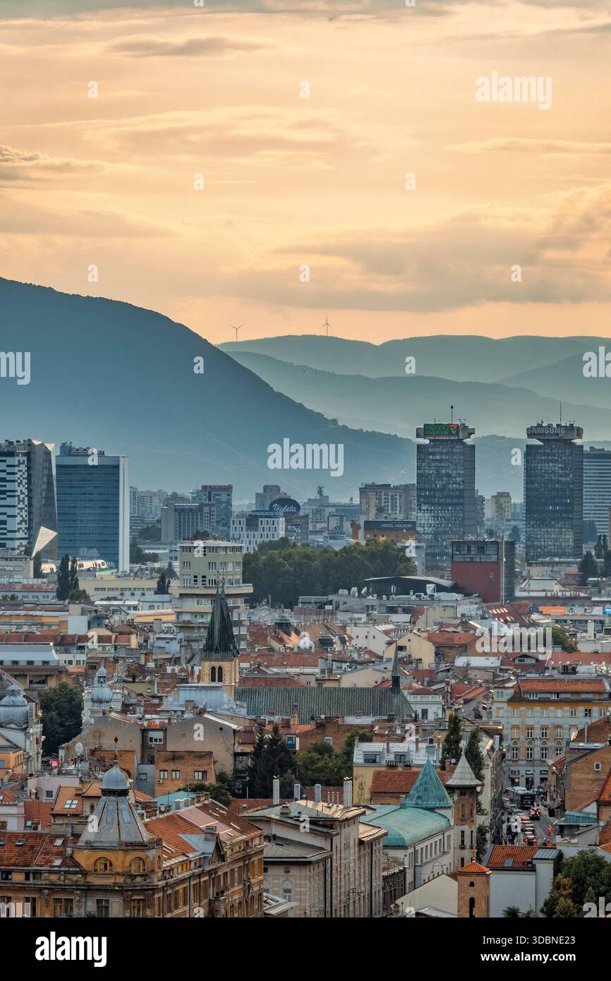 Vista panoramica di Sarajevo con un mix di tetti storici, chiese, moschee e moderni grattacieli, circondati dalle montagne, Bosnia ed Erzegovina Foto Stock