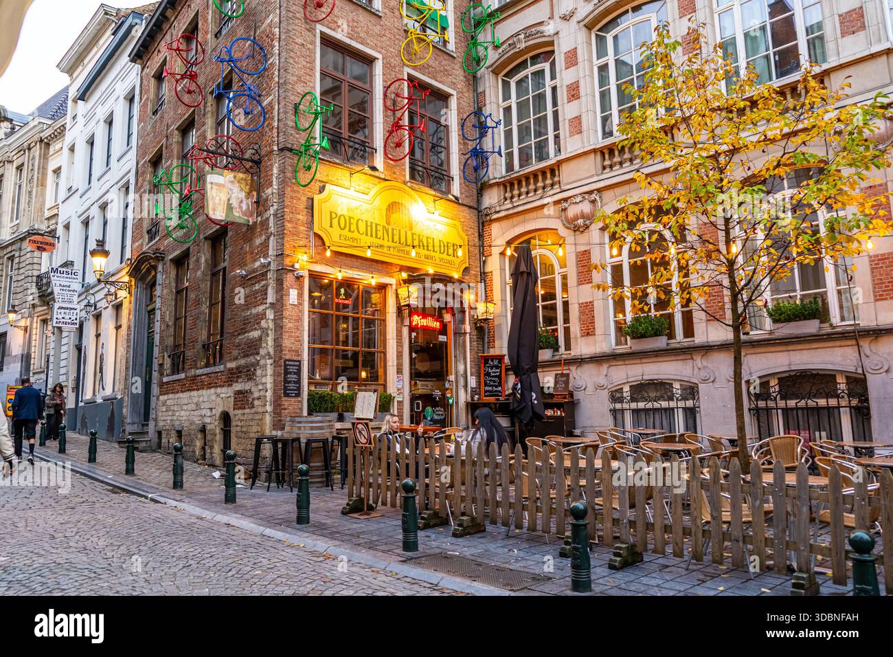 Bruxelles, Belgio - 28 ottobre 2025: Bar Poechenellekelder per le strade di Bruxelles. Caffetteria con vecchio negozio. Tavolo da cibo di strada nel bistrot Foto Stock
