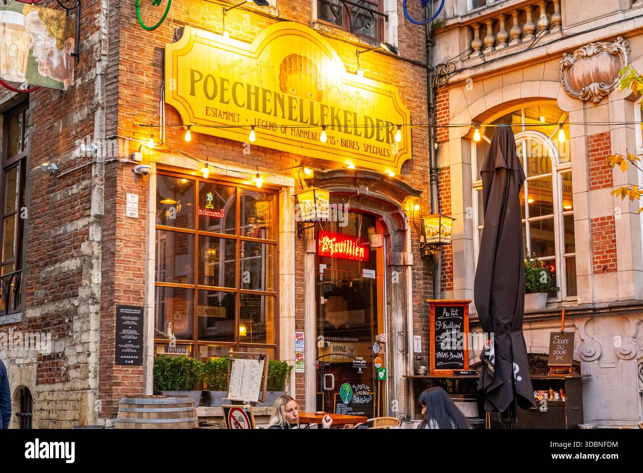 Bruxelles, Belgio - 28 ottobre 2025: Via Poechenellekelder bar di Bruxelles. Caffetteria con vecchio negozio. Cartello porta d'ingresso Foto Stock