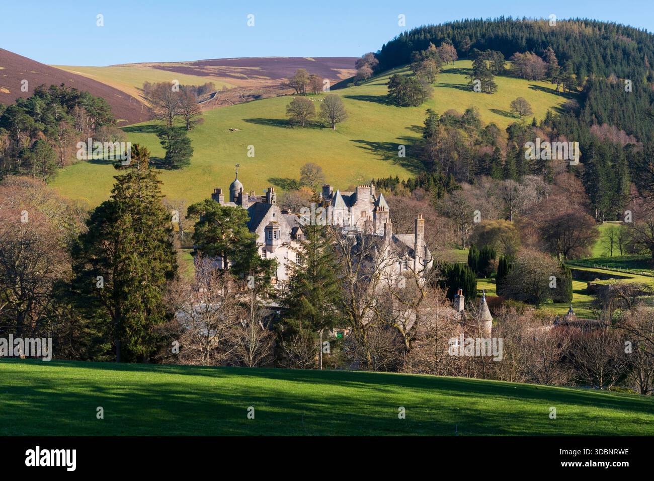Storica Glen House tra colline ondulate, alberi e vegetazione in un tranquillo paesaggio di campagna scozzese. Foto Stock