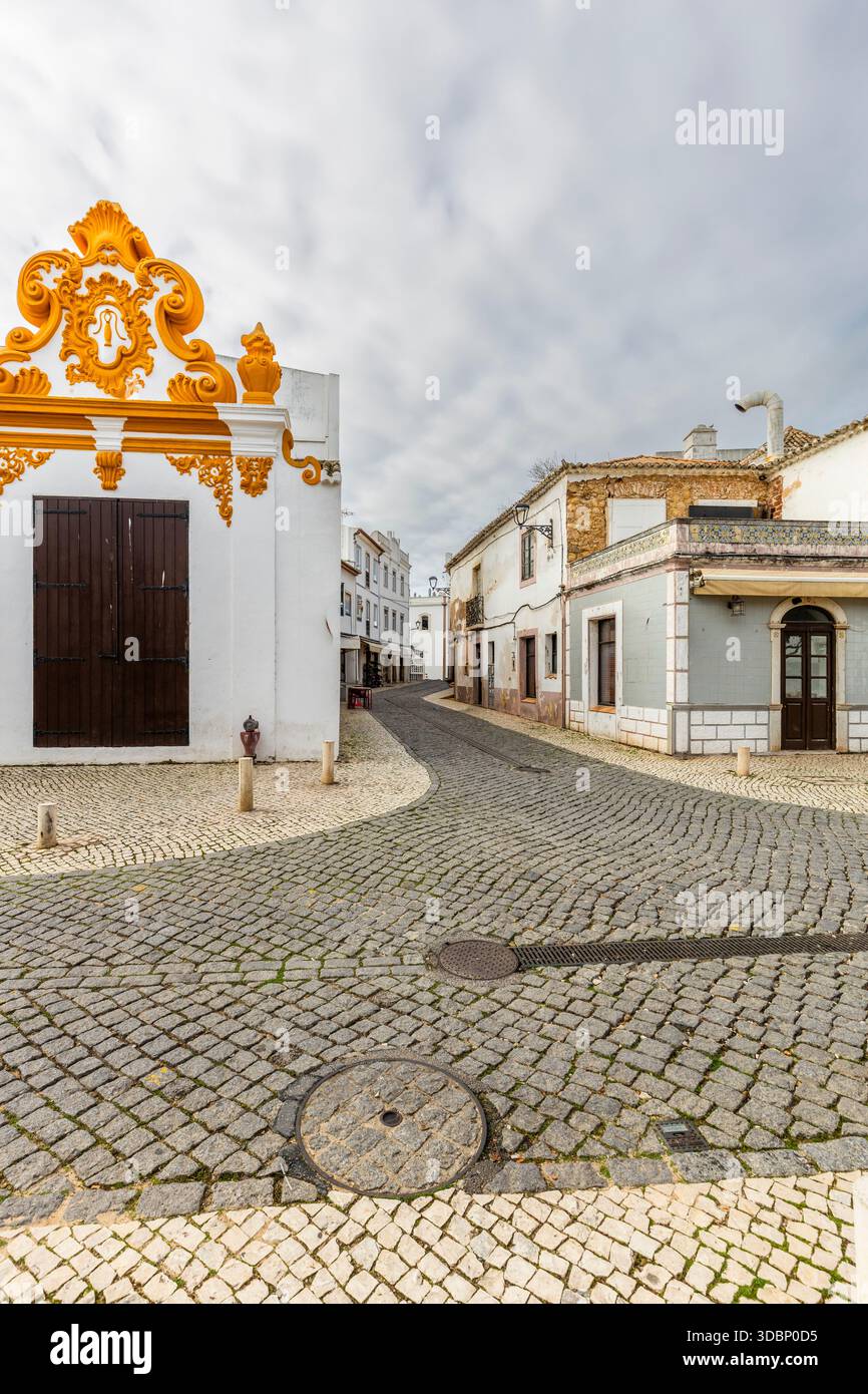 Tranquilla e tradizionale strada acciottolata fiancheggiata da edifici storici a Lagos, Algarve, Portogallo. Foto Stock