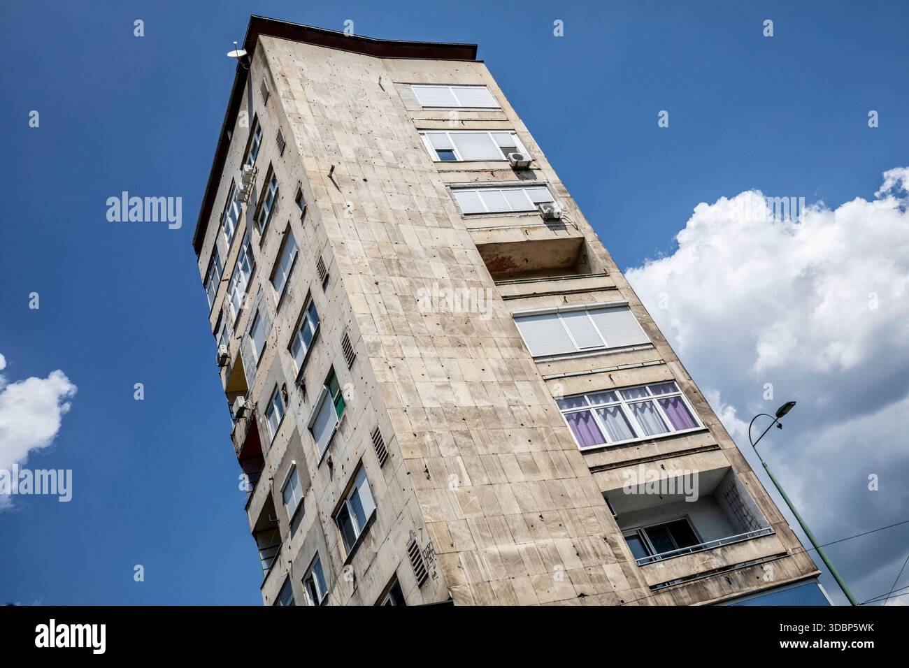 Facciata di un edificio lungo Ulica Zmaja od Bosne (Viale dei cecchini) a Sarajevo, che mostra fori proiettili, danni e contrasto architettonico tra finestre e pareti, Sarajevo, Bosnia ed Erzegovina Foto Stock