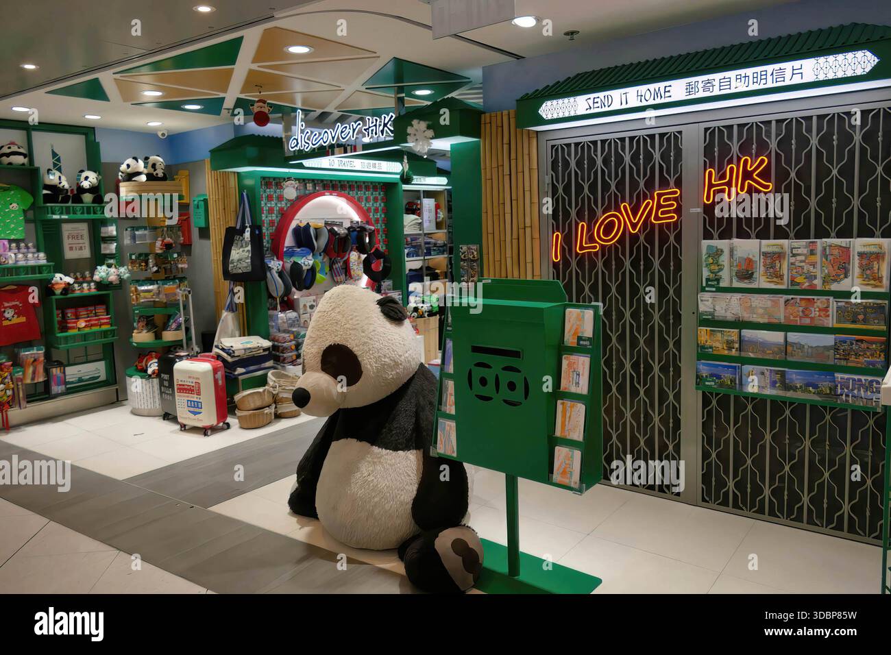 HONG KONG - DEC 7, 2019 - interni del negozio di souvenir di Hong Kong con mascotte gigante di panda, cassetta postale verde e luccicante cartello al neon i Love HK, esposizione colorata Foto Stock