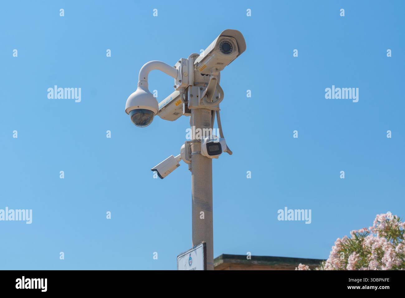 Telecamera di sicurezza stradale montata su un palo contro il cielo azzurro. Sorveglianza urbana, pubblica sicurezza e moderno concetto di infrastruttura urbana Foto Stock