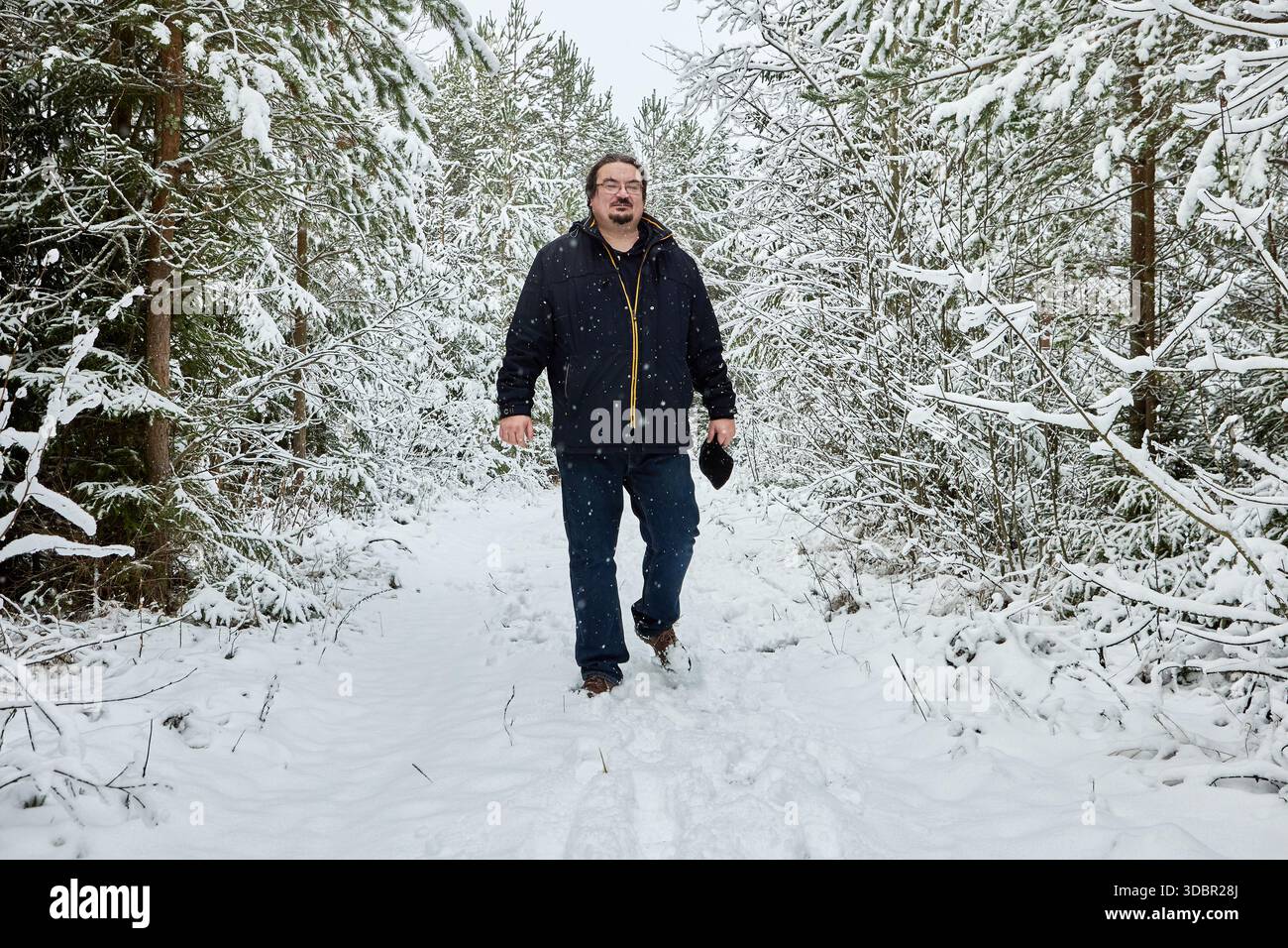 Perduto nella foresta invernale innevata, il grande uomo 50 cerca di trovare la via di casa. Foto Stock