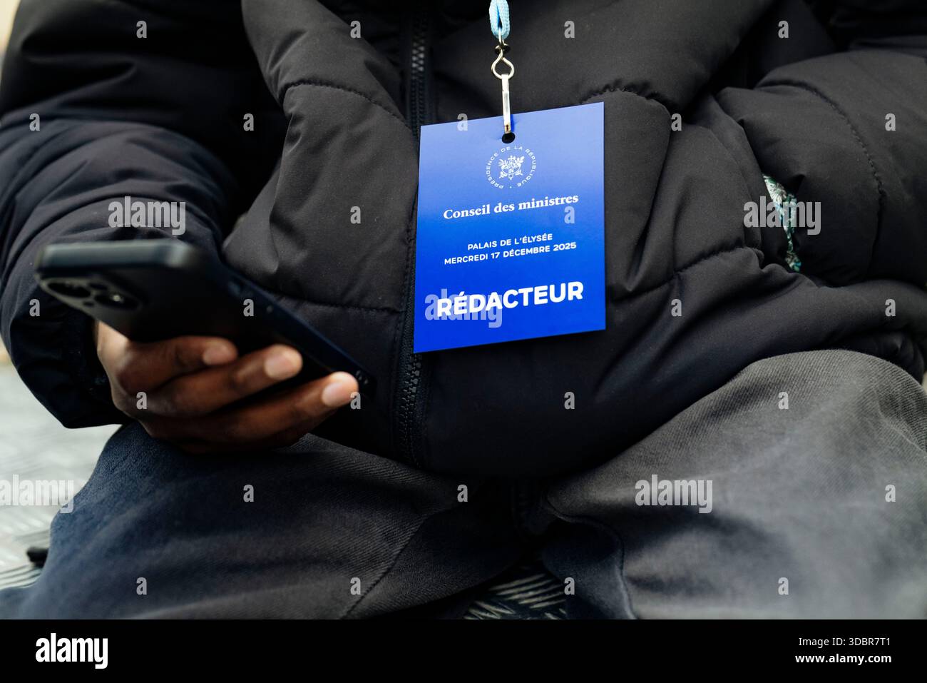 Un giovane montatore tirocinante della BFM, con il suo pass per la stampa e lo smartphone in mano. Governo di Sebastien Lecornu. Uscita dalla riunione del Consiglio dei ministri tenutasi mercoledì 17 dicembre presso il Palazzo Elysee. Francia, Parigi, 17 dicembre 2025. Fotografia di Patricia Huchot-Boissier / Agence DyF. Un jeune Redacteur stagiaire de BFM, avec son Accredited et son smartphone à la Main. Gouvernement de Sebastien Lecornu. Uscita del Conseil des ministres qui s est tenu ce mercredi 17 décembre, au Palais de l'Elysee. Francia, Parigi le 17 décembre 2025. Photographie de Patricia Huchot-Boissier / Agence DyF Foto Stock