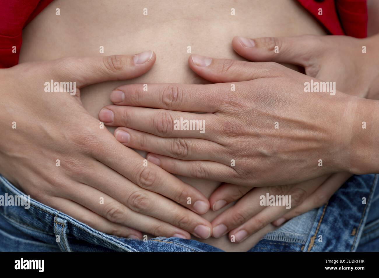 Immagine simbolica della gravidanza, mani stese sullo stomaco di una donna Foto Stock