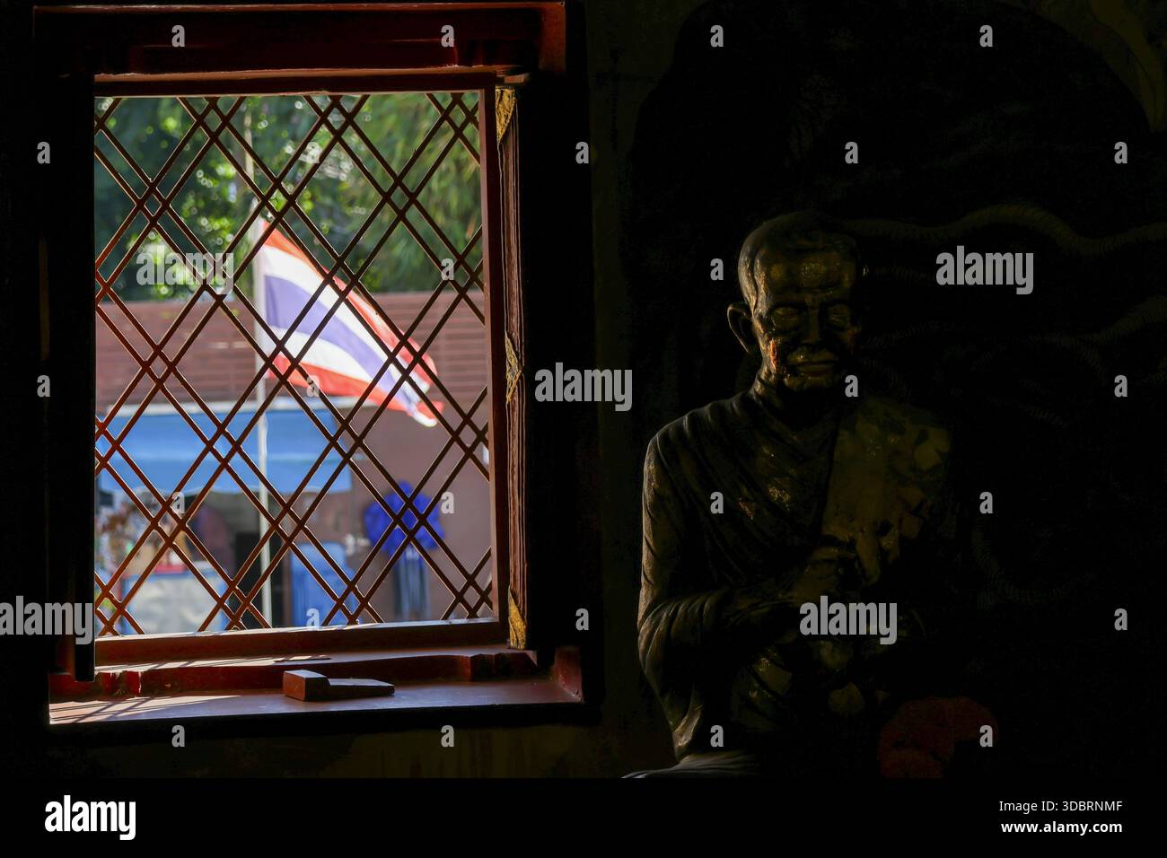 La cornice della finestra con griglia a reticolo che guarda alla bandiera thailandese la brezza fluttuante evoca una sensazione di orgoglio nazionale e di profondo rispetto per la sagoma omata del limone Foto Stock