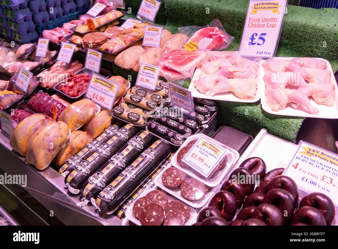 Mercato di seppellimento e bancarelle di cibo che vendono budini neri, carne e pollo, Greater Manchester, Inghilterra, Regno Unito Foto Stock