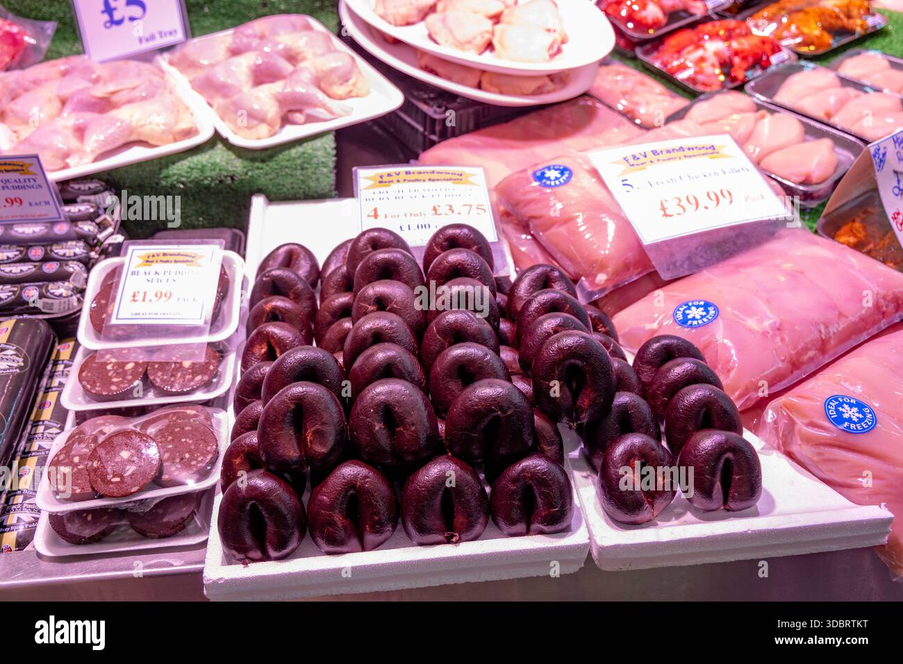 Budini neri in vendita presso una macelleria nel mercato alimentare al coperto del centro di Bury, Greater Manchester, Inghilterra, Regno Unito Foto Stock