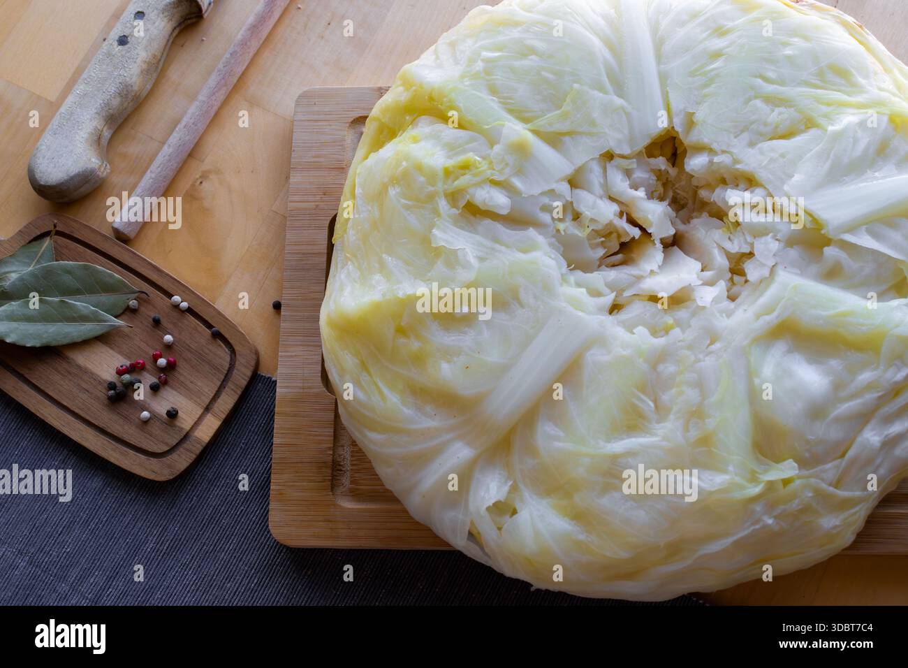 Processo di preparazione di involtini di cavolo ripieni fatti in casa con carne macinata, riso e spezie in un'accogliente cucina casalinga. Tradizionale preparazione di cibi confortevoli Foto Stock