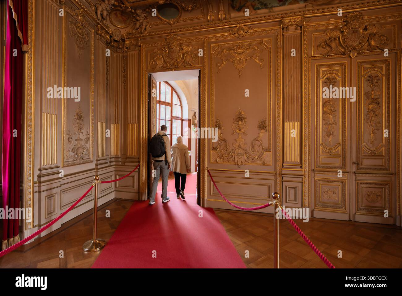 Sigmaringen, Germania - 09 settembre 2025: Vista dell'interno del castello di Hohenzollernschloss, dove dettagli in oro ornato contrastano con il ricco tappeto rosso Foto Stock