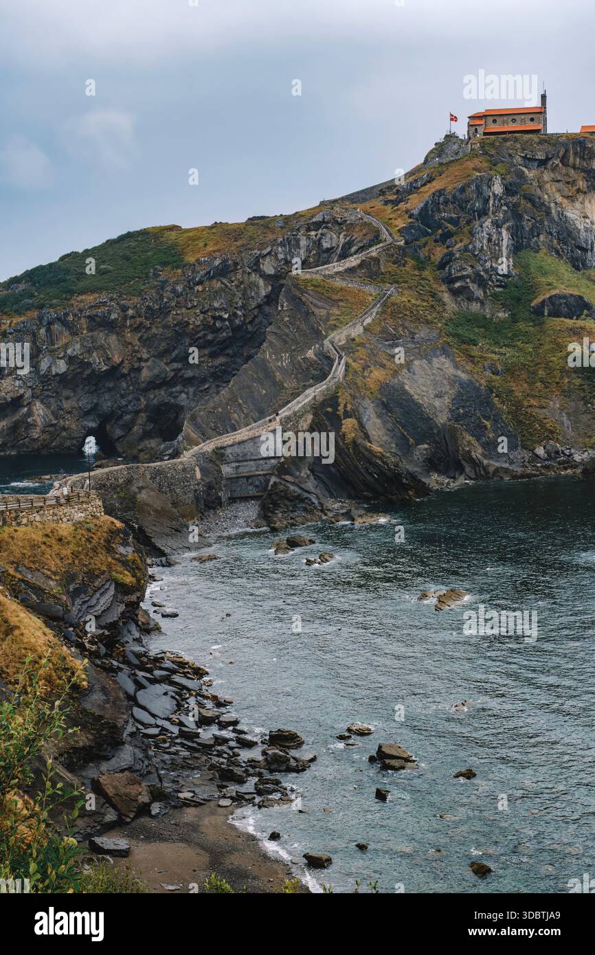 San Juan de Gaztelugatxe Hermitage sulla scogliera con il sentiero di pietra, Spagna Foto Stock
