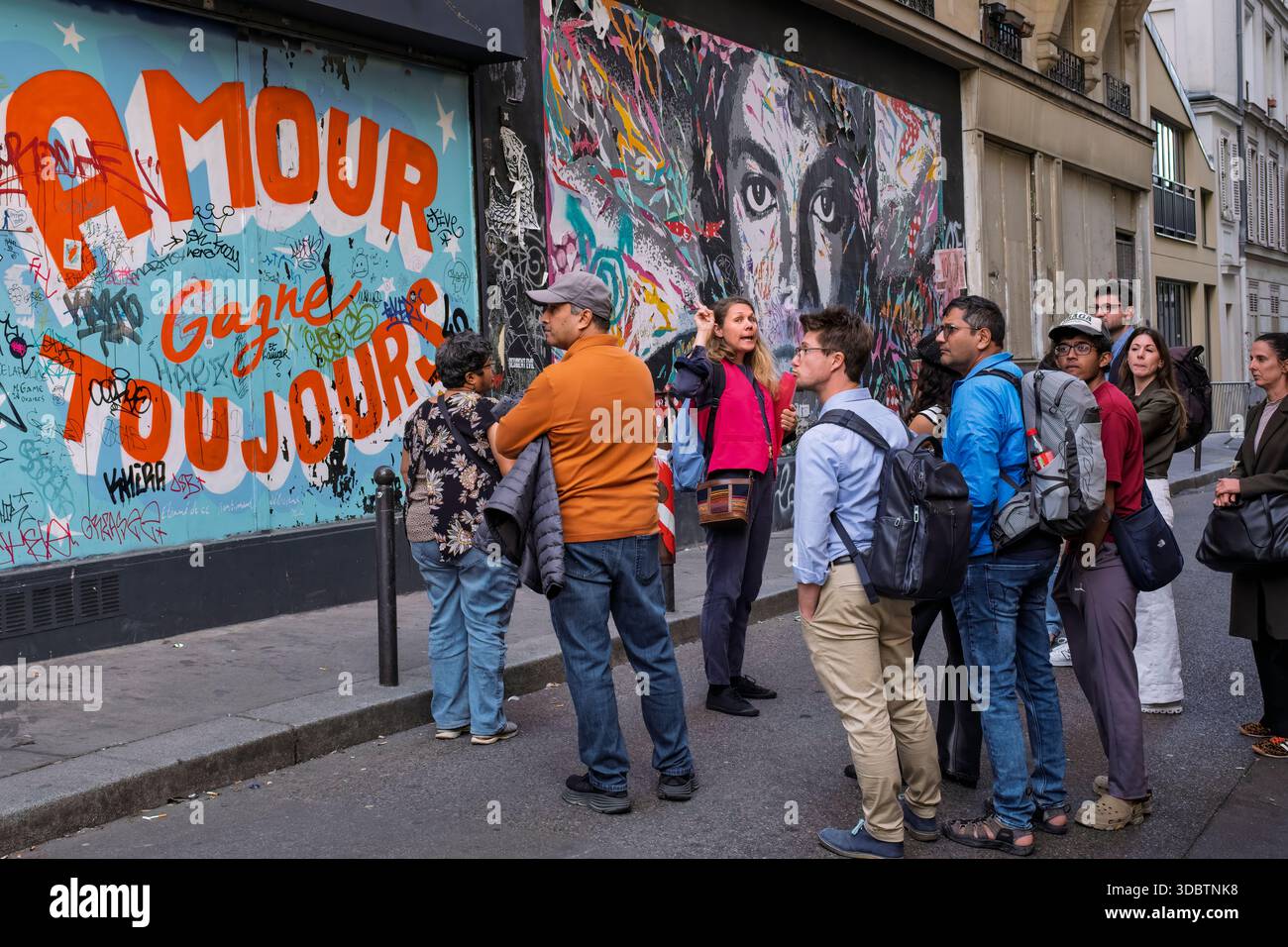 Un gruppo che guarda l'arte dei graffiti a Montmartre, Parigi Foto Stock