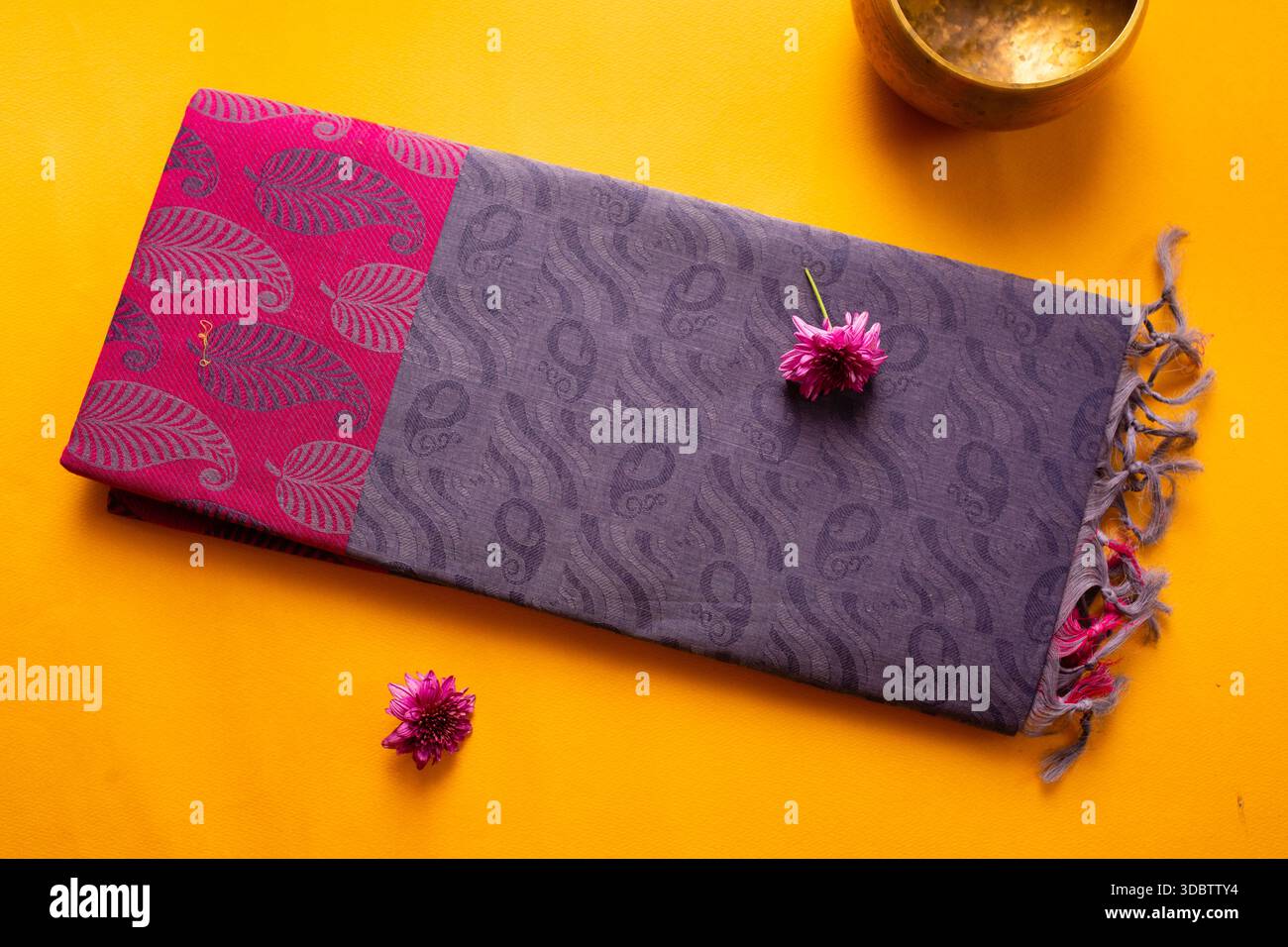 Sari di cotone piegati di Erode, Tamil Nadu, India su sfondo giallo Foto Stock