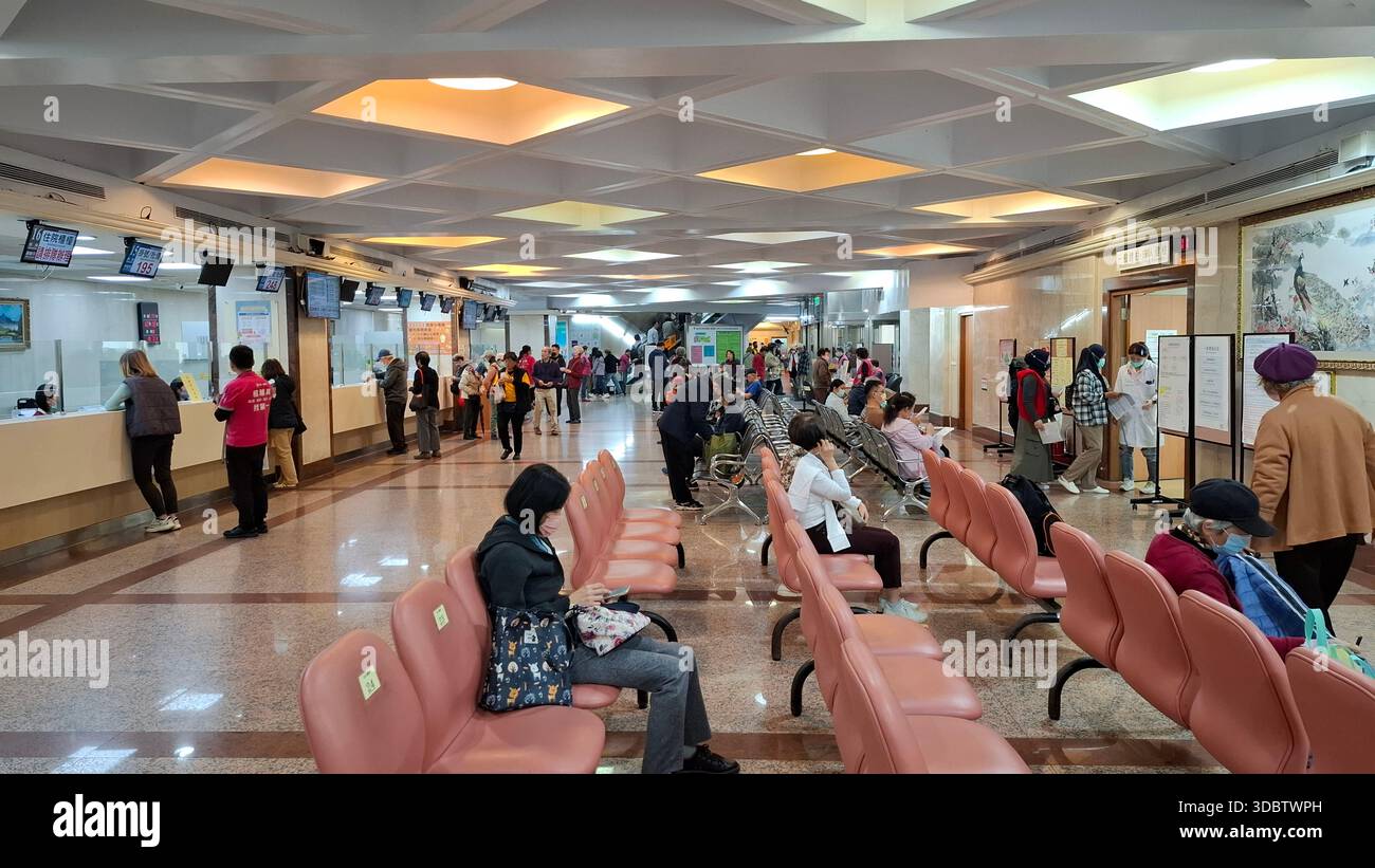 Taipei, Taiwan, 18 dicembre 2025. I pazienti attendono nell'area di ricezione dell'ospedale con contatori di servizio e visualizzazioni digitali della coda Foto Stock