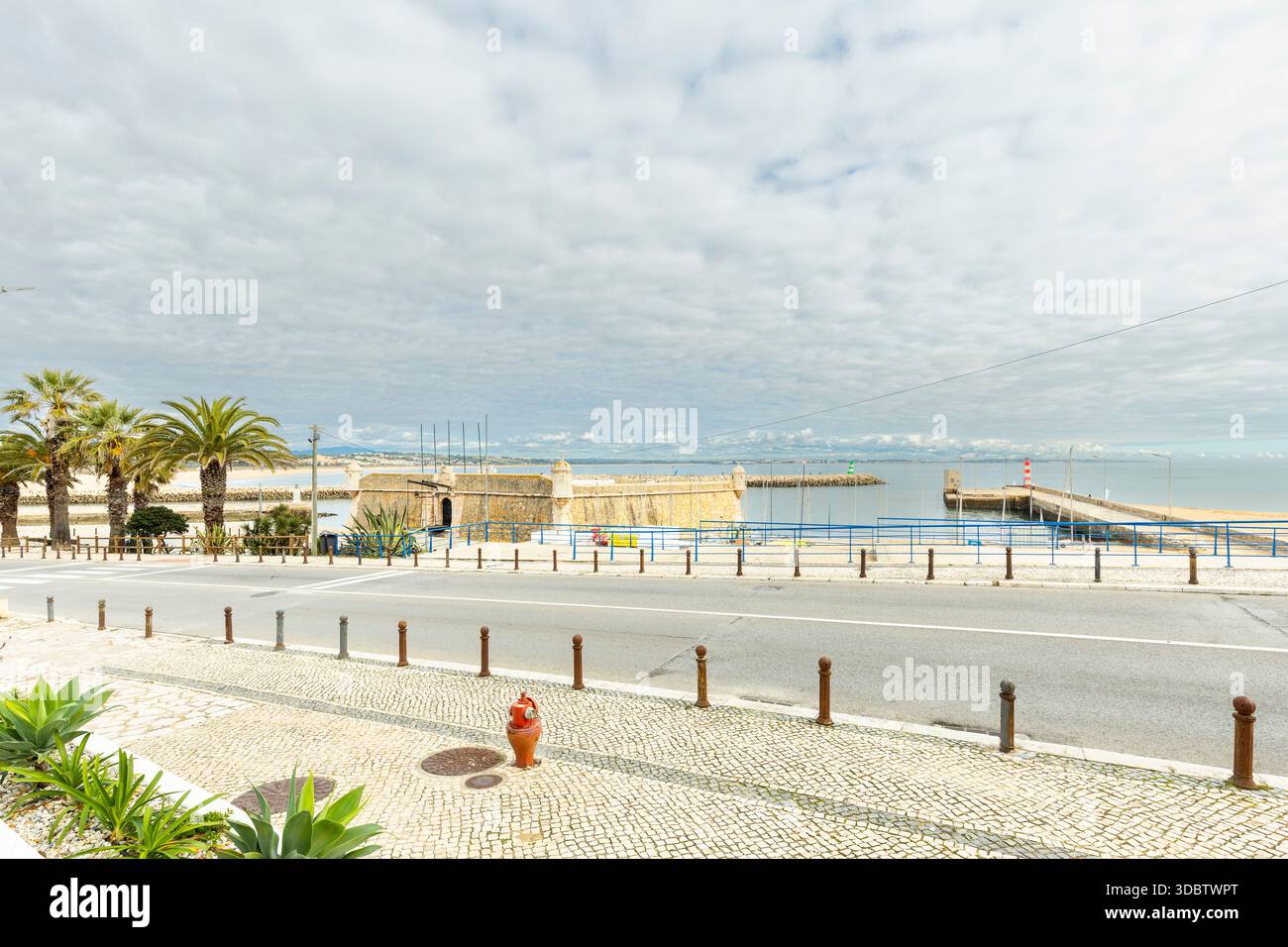 Storica fortezza costiera a Lagos, Algarve, Portogallo, affacciata sull'Oceano Atlantico. Antiche mura di pietra e torri di guardia sotto un suggestivo cielo blu W. Foto Stock