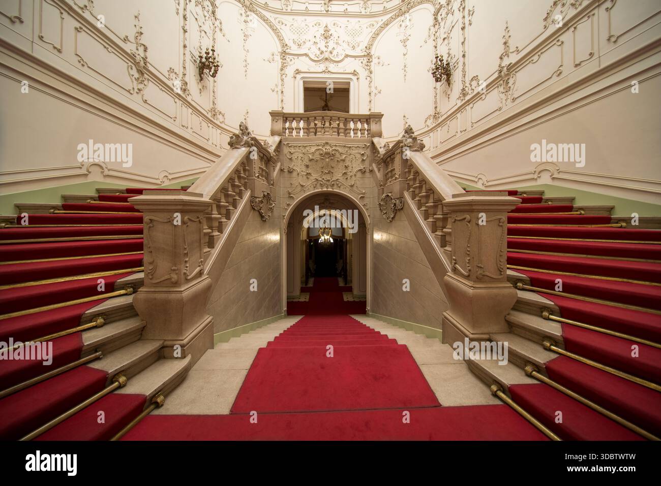 Grande scalinata ornata con tappeto rosso all'interno di uno storico palazzo di Budapest Foto Stock