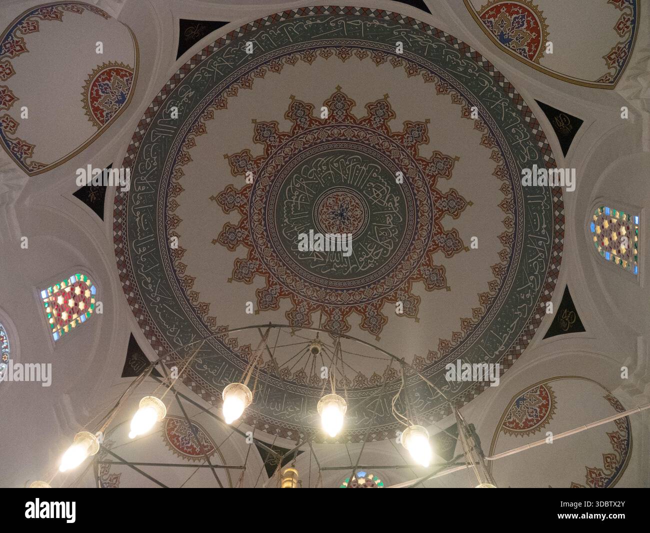 Cupola ottomana decorata con calligrafia araba e lampadario sospeso in una moschea di Istanbul Foto Stock