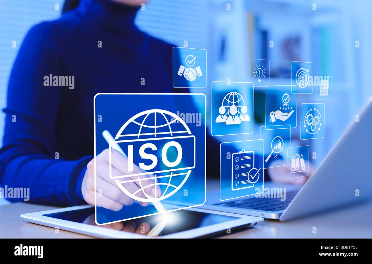 Certificazione ISO e concetto di gestione della qualità. Una donna d'affari utilizza tablet e laptop con icone di certificazione ISO, standard internazionali, conforme Foto Stock