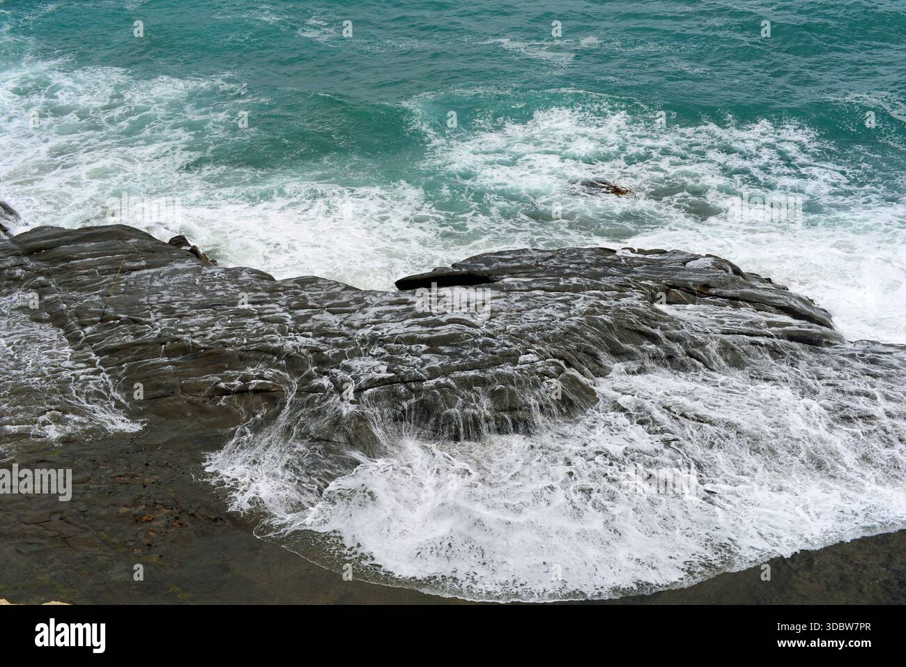 Onde di mare scosceso che si innalzano su una roccia a Muriwai, North Island, nuova Zelanda Foto Stock