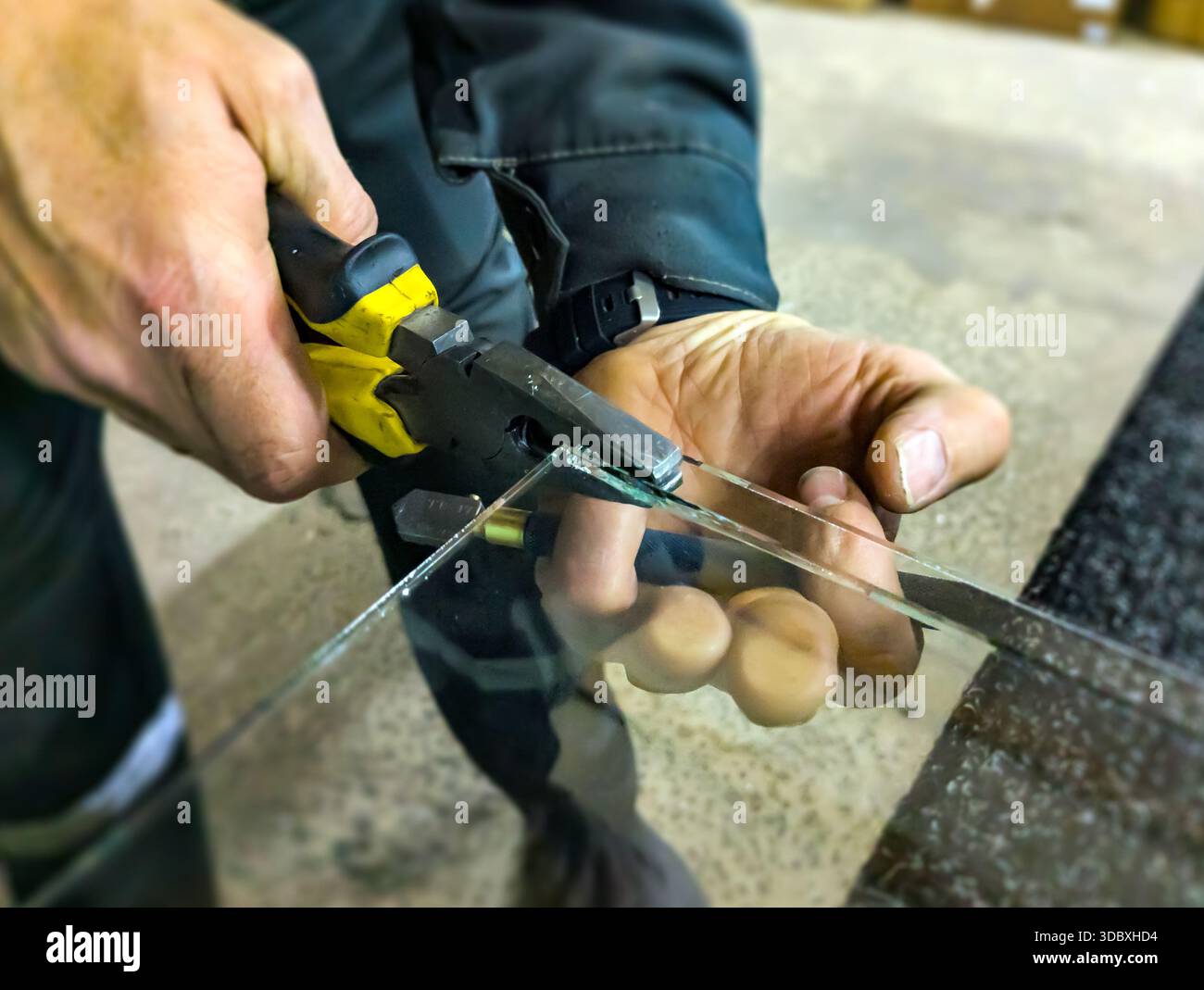 Rompere il vetro in eccesso durante il taglio con le pinze Foto Stock
