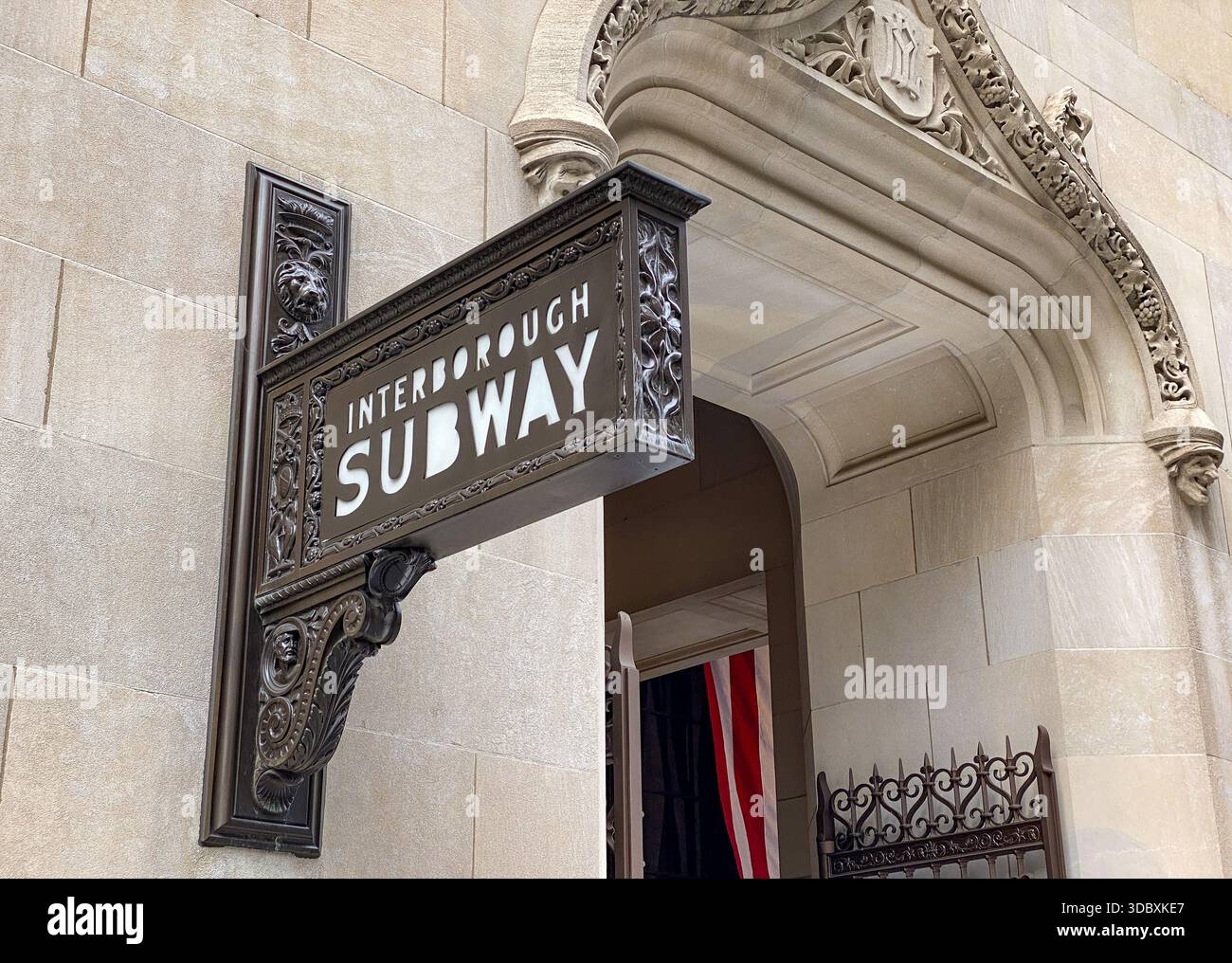 Vista di un'insegna d'epoca decorata della metropolitana di Interborough appesa alla facciata in pietra di un edificio, che suggerisce le profondità nascoste della città, New York, New York Foto Stock