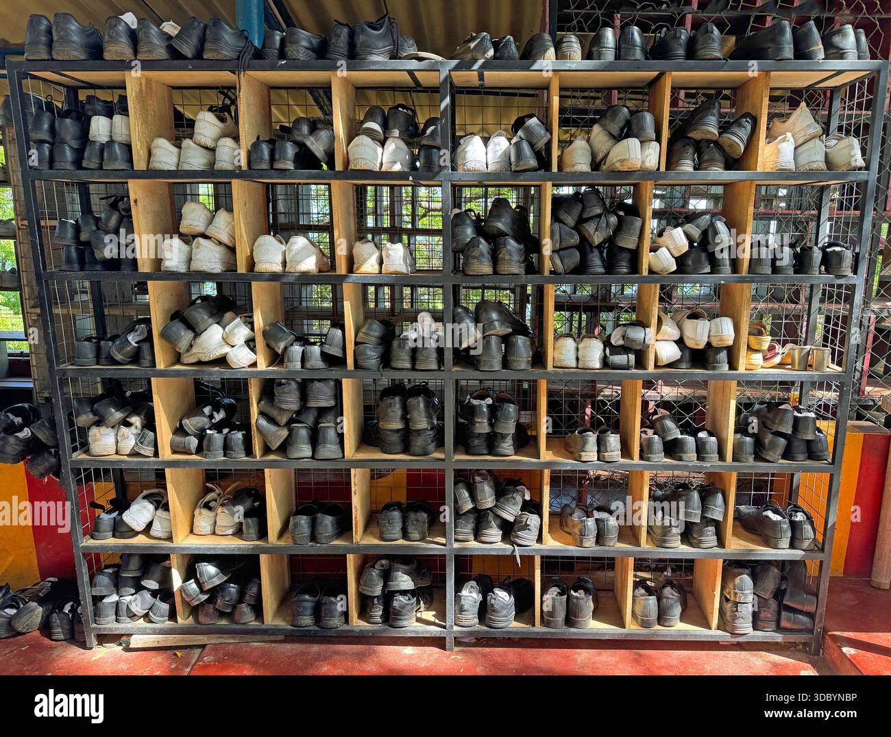 Scarpe di persone che pregano in una cremagliera. Foto Stock