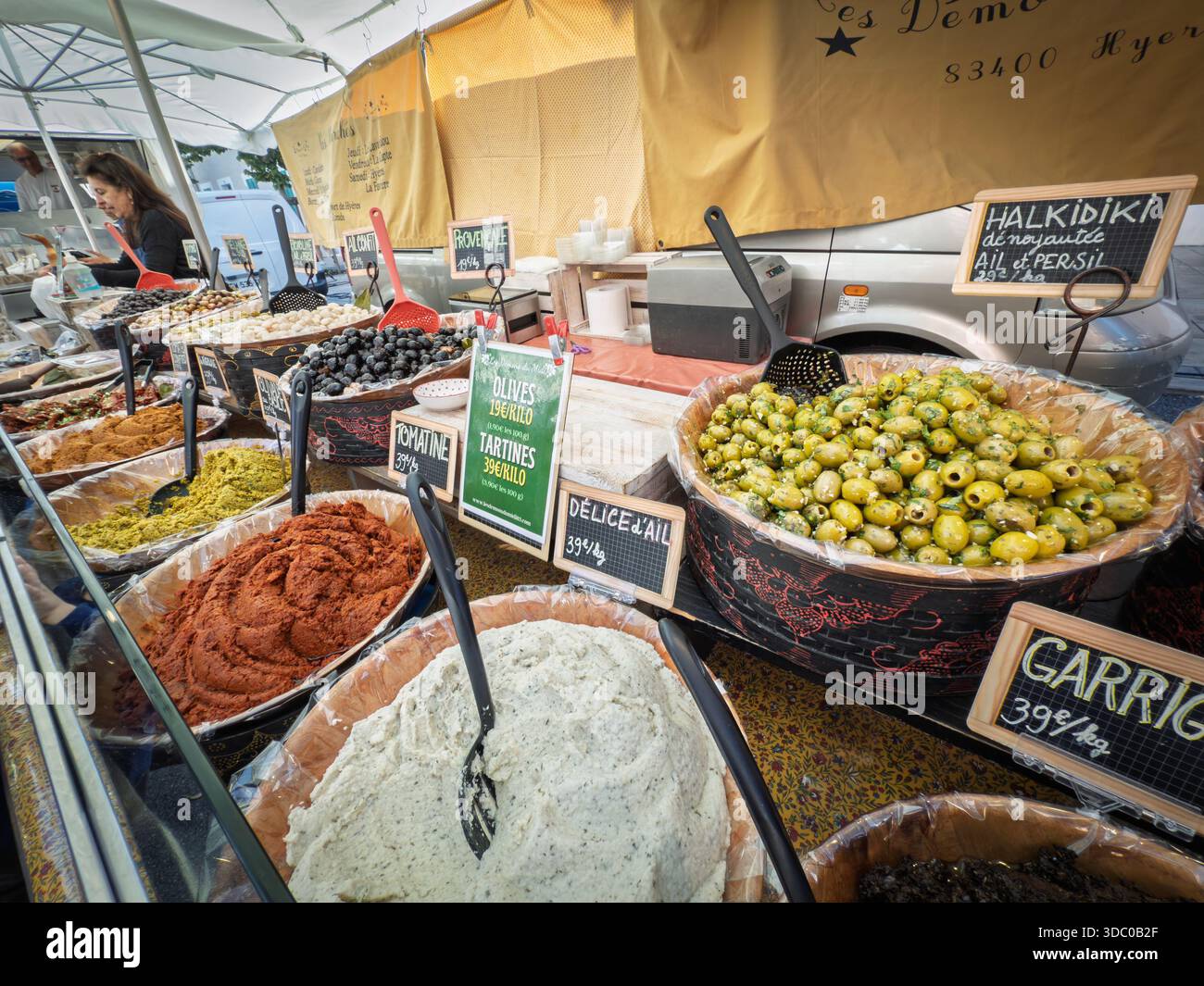 LA LONDE, FRANCIA - 28 SETTEMBRE 2025: Bancarello del mercato provenzale a la Londe espone ciotole di olive, tapenades e aioli che illustrano il foo mediterraneo Foto Stock
