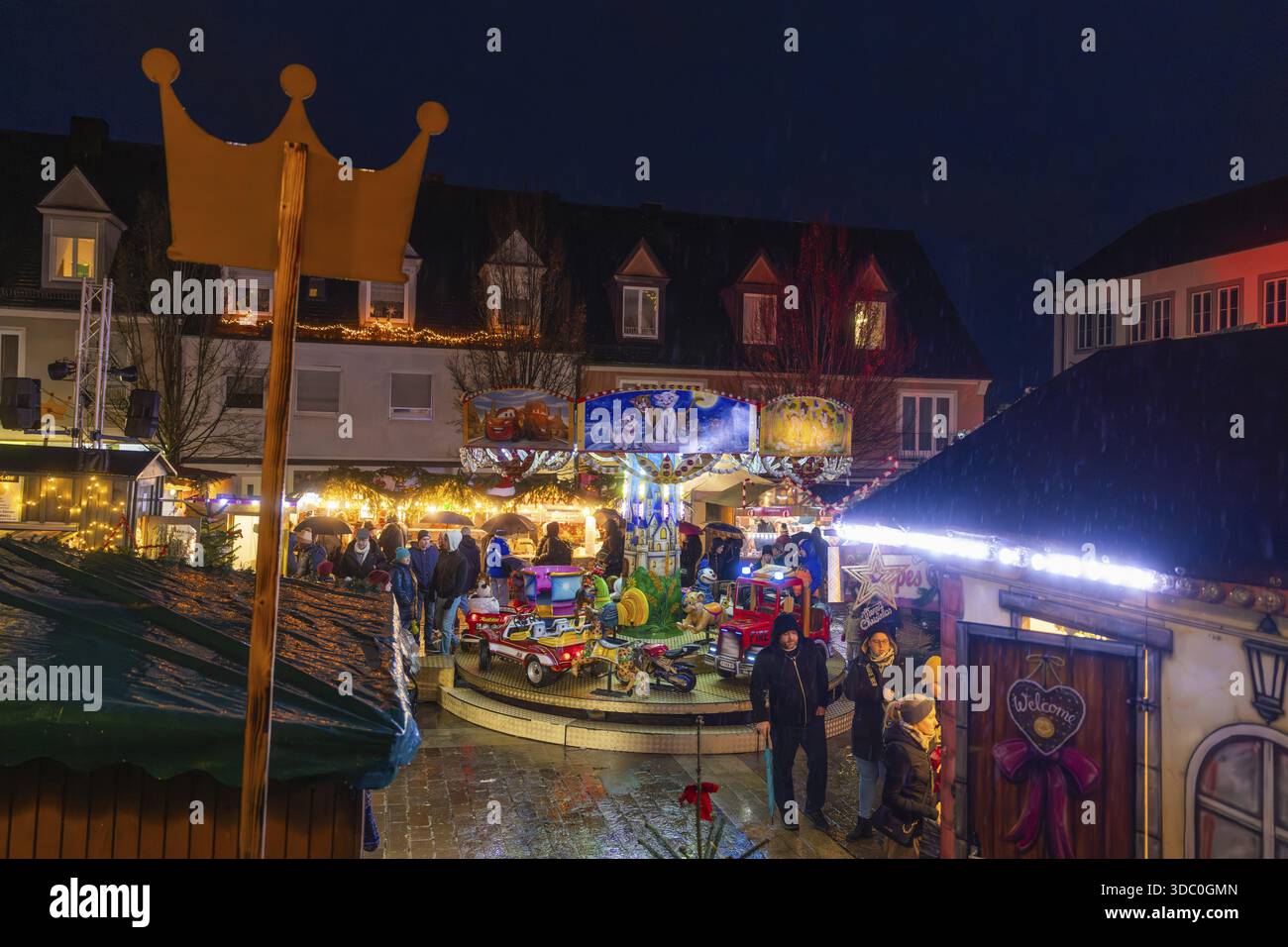 Panoramica di un mercatino di Natale con corona, giostra e luci festive di notte, mercato di Natale di Boeblingen, Germania Foto Stock