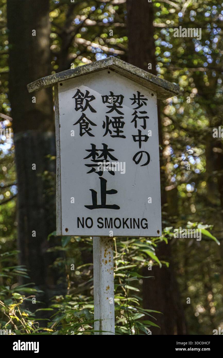 Un cartello nella foresta vieta di fumare e mangiare con iscrizioni giapponesi e inglesi Foto Stock