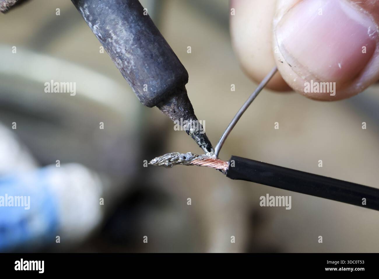 Vista ravvicinata che mostra il filo elettrico per la riparazione manuale del tecnico con l'utensile per saldatore e il riscaldamento del metallo al piombo con precisione e attenzione Foto Stock