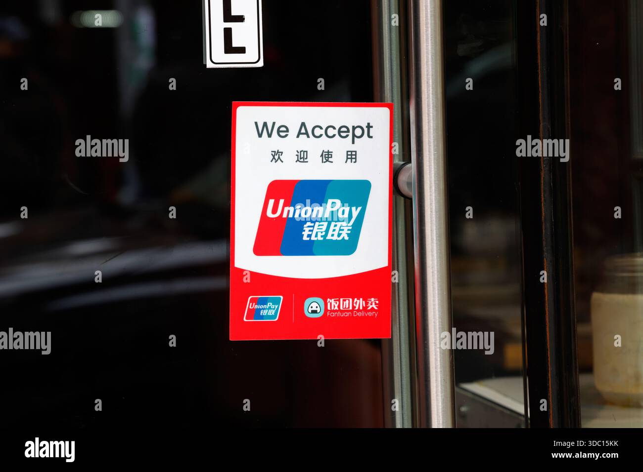 Un cartello "Welcome to use UnionPay 欢迎使用" (benvenuto per utilizzare UnionPay) a una porta di un'azienda. Union Pay è una società cinese di servizi finanziari specializzata nel pagamento con carta di credito Foto Stock