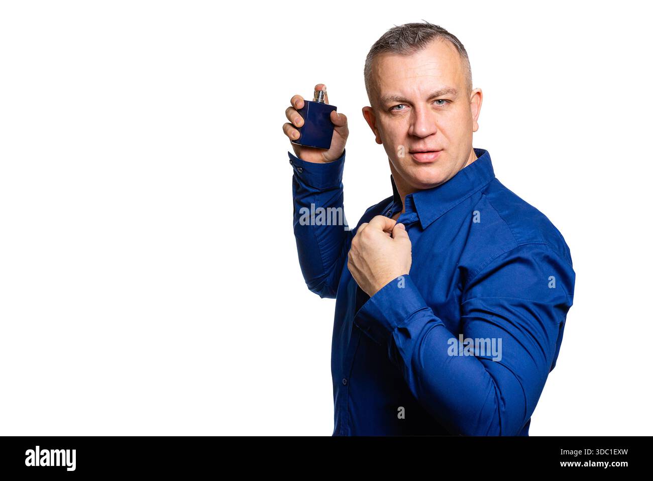Uomo che tiene in mano spray profumato, fragranza, stile e concetto di cura personale Foto Stock