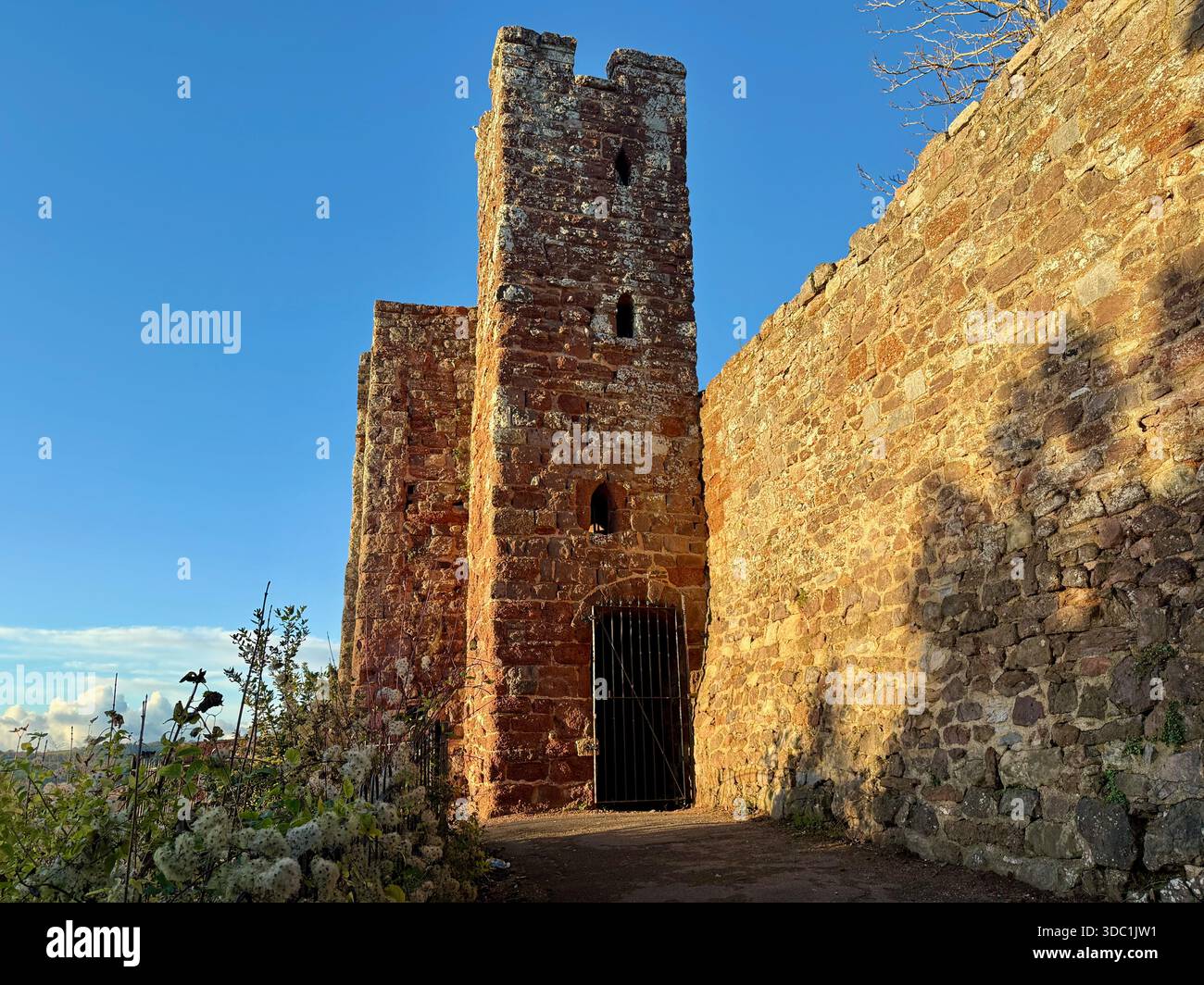 L'antica torre in arenaria rossa delle antiche mura del castello di Exeter nei giardini Rougemont - Immagine stock catturata con smartphone