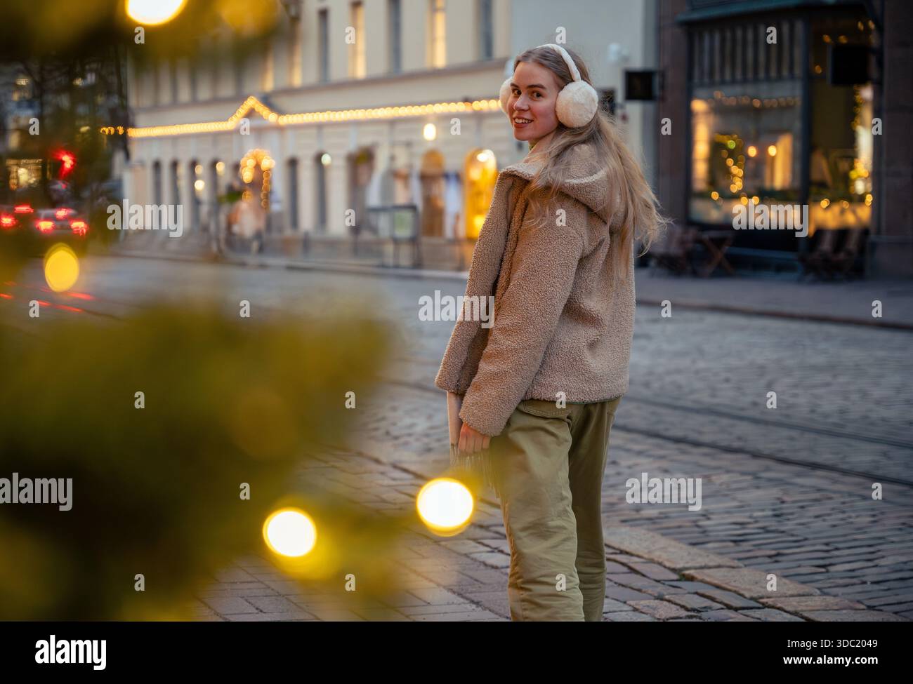 Giovane donna che indossa le cuffie al mercatino di Natale di Helsinki, Finlandia Foto Stock