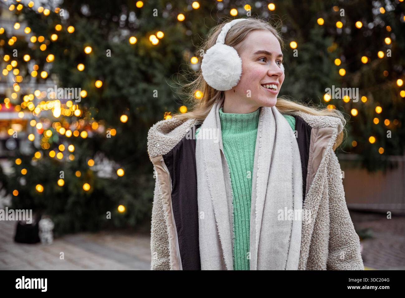 Giovane donna che indossa le cuffie al mercatino di Natale di Helsinki, Finlandia Foto Stock