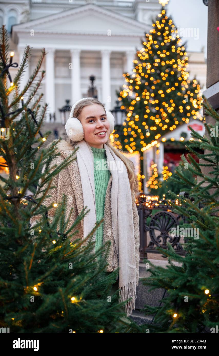 Giovane donna che indossa le cuffie al mercatino di Natale di Helsinki, Finlandia Foto Stock