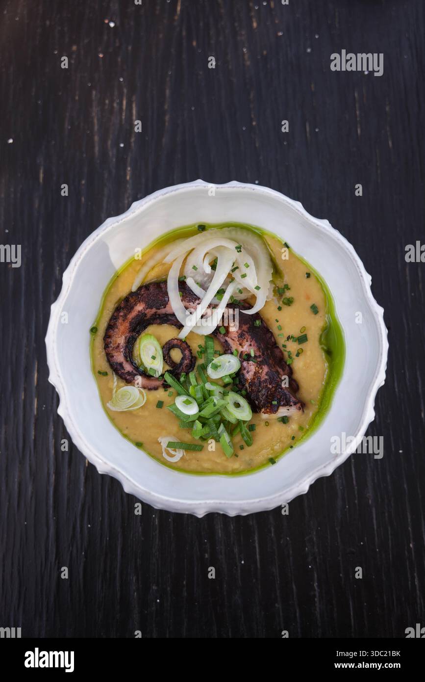Piatto gourmet di polpo con salsa cremosa e cipolle primaverili, Creta Grecia. Cucina greca tradizionale a base di pesce. Cucina mediterranea del ristorante. Foto Stock