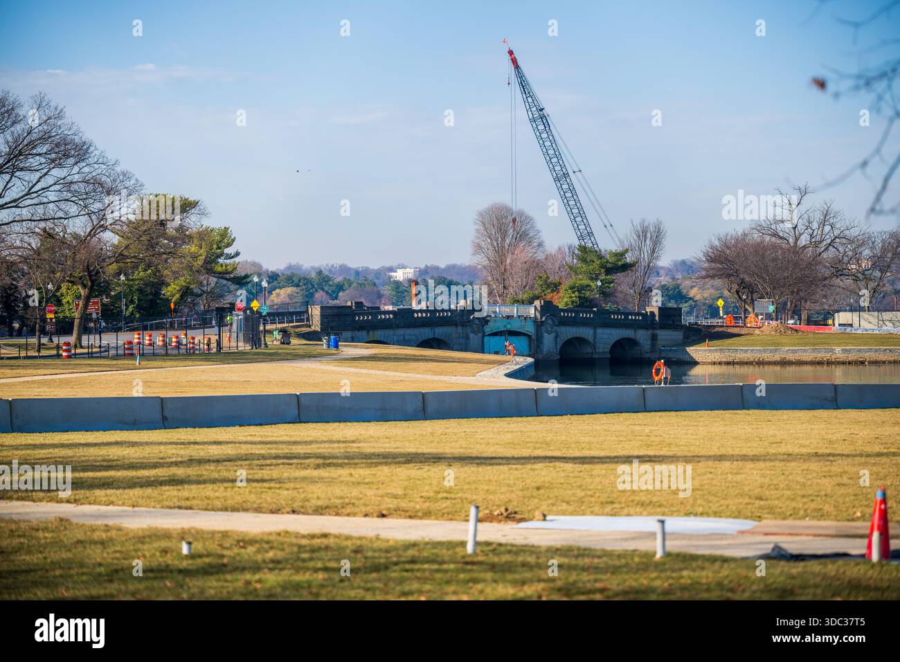 Tidal Basin Seawall Reconstruction Phase 1 complete Washington DC // WASHINGTON DC — il Tidal Basin Seawall Rehabilitation Project è visto con la costruzione in corso vicino all'Inlet Bridge e alle aree erbose di recente. La fase 1, che copre il lato del bacino di marea della diga, fu ufficialmente completata il 10 dicembre 2025, prima del previsto e circa 30 milioni di dollari sotto il suo budget di 113 milioni di dollari. Il progetto complessivo, finanziato dal Great American Outdoors Act, è otto mesi prima del previsto, con la fase 2 sul fiume Potomac che dovrebbe terminare entro maggio 2026. Il Seawall ricostruito presenta profonde caratteristiche Foto Stock