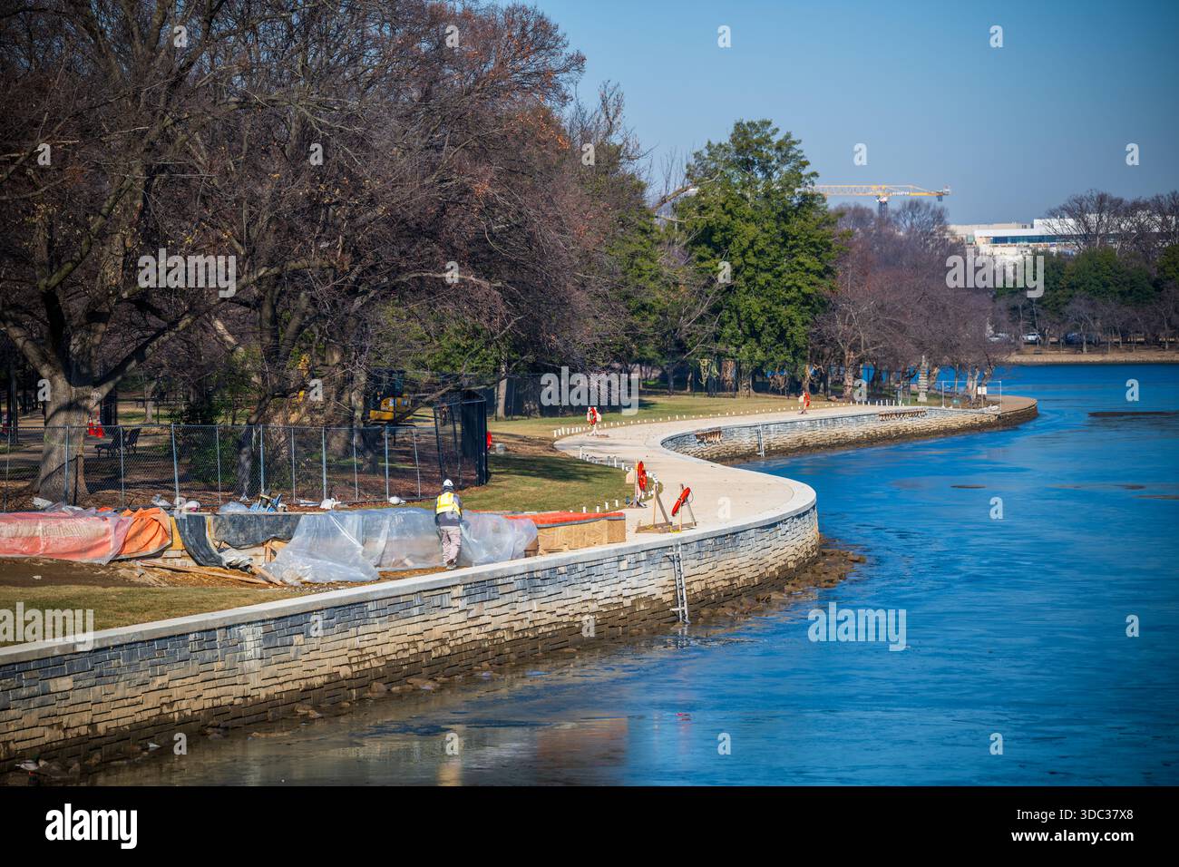 Tidal Basin Seawall Reconstruction Phase 1 Washington DC // WASHINGTON DC — Una sezione appena completata del Tidal Basin Seawall Project è visibile vicino a Inlet Bridge il 18 dicembre 2025. La fase 1 fu completata prima del previsto e con un budget di 30 milioni di dollari, finanziato dal Great American Outdoors Act. La diga è stata ricostruita, rinforzata e sollevata di circa 4,75 - 5 piedi (1,45 - 1,52 metri). Gran parte dell'area è ora erbosa, con la piantagione di alberi prevista per la primavera 2026. Le zone di costruzione rimarranno chiuse durante il Festival nazionale della fioritura dei ciliegi del 2026, mentre la fase 2 mira a M Foto Stock