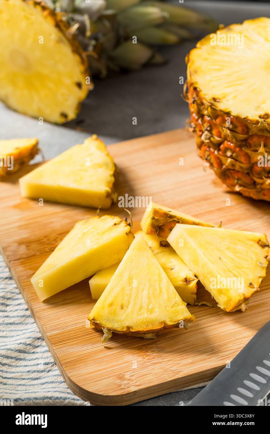 Fette di ananas crudo organico su un tagliere Foto Stock