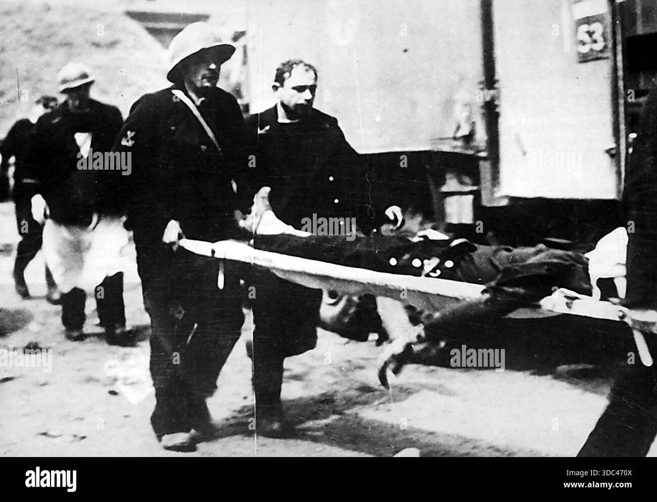 Un'altra vittima innocente della vendetta nazista -- operai francesi dell'A.R.P. che trasportano un civile ferito forse ucciso dalle bombe sganciate da TH Foto Stock