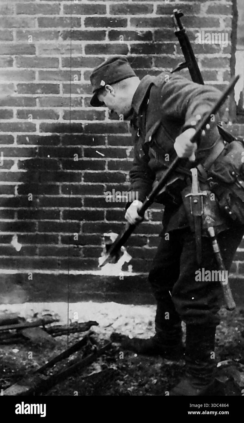 Soldato finlandese incendierà l'edificio - Un soldato finlandese che si prepara a dare fuoco a una casa nella zona di guerra della Finlandia. E' la politica dei finlandesi Foto Stock