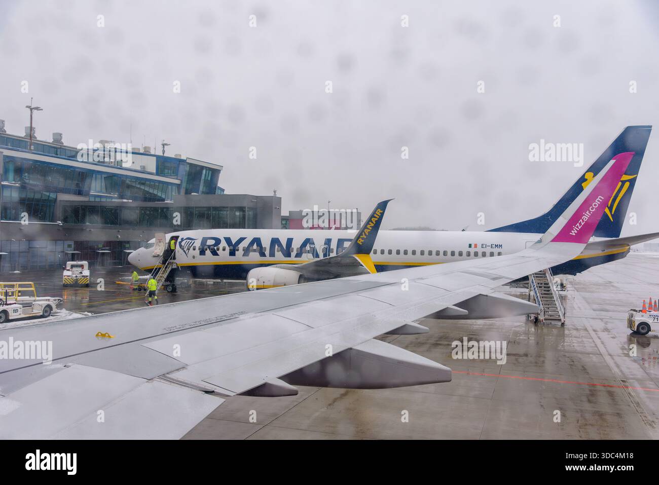 Ozarowice, Polonia - 23 novembre 2025: Una vista da un posto vicino al finestrino che guarda un aeromobile Ryanair Boeing 737 parcheggiato sull'asfalto bagnato di fronte al Foto Stock